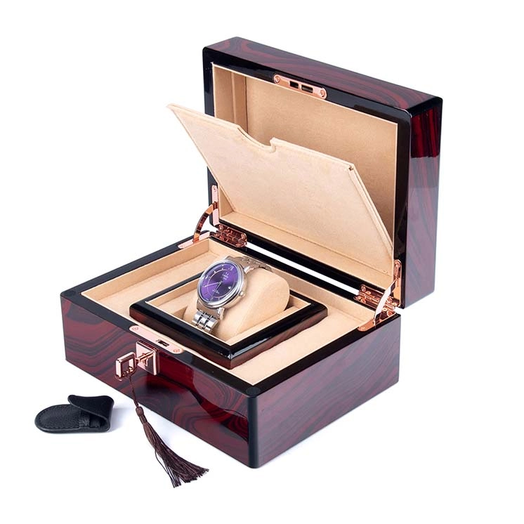Open polished wooden watch case with a single watch on a cushion